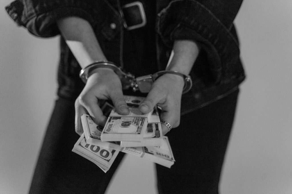 Cuffed hands holding Money